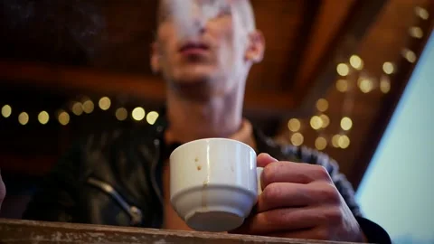 White mug with drips of coffee in the hands of a bald young man Stock Footage 162318559