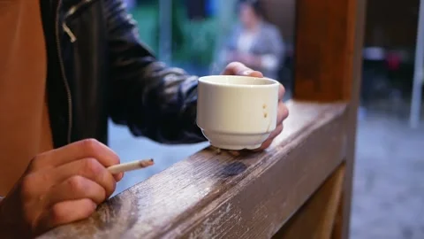White mug with drips of coffee in the hands of a bald young man Stock Footage 162318560