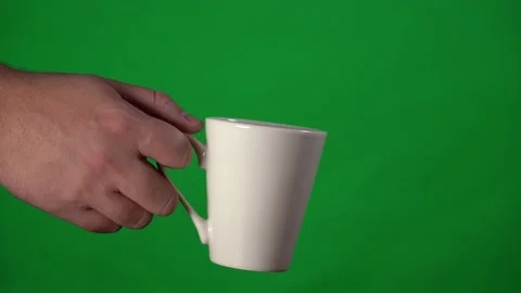 White mug in a man's hand close-up on the background of a chromakey Stock Footage 143003656