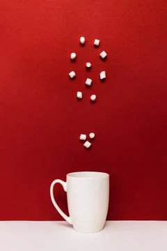 White mug with marshmallows arranged in a question mark shape on a vibrant .. Stock Photos
