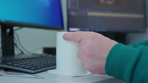 A white mug stands on the table next to the computer monitor. Stock Footage 276970251