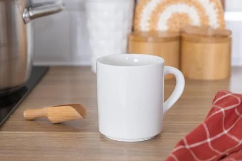 The white mug, a staple of any kitchen, is positioned centrally on the wooden Stock Photos