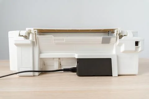 White Multifunction Printer With Ink Tank And Power Cable On Desktop Office.. Stock Photos