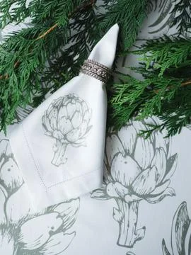 White napkin with a silver ring on the table, thuja twigs Stock Photos