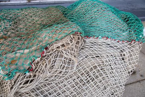 A white net that features a green border rests on a concrete surface Stockfoto's