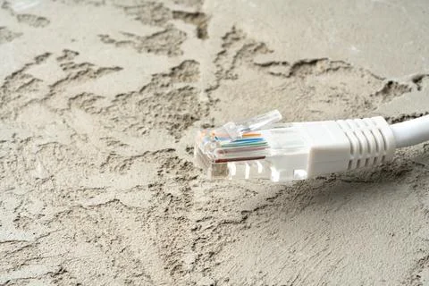White network cable patch-cord on gray textured background Stock Photos