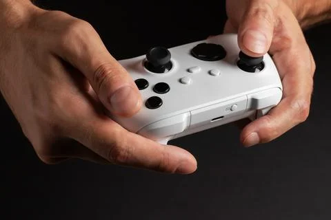 White next gen controller in man hands on dark background Фото