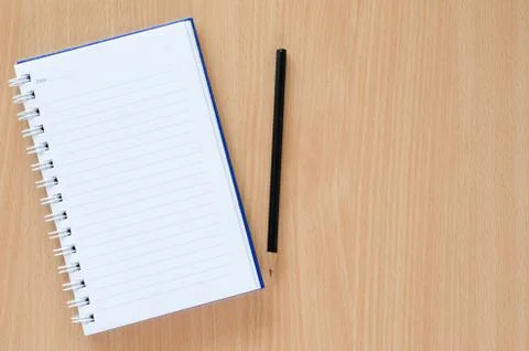 White note book and black pencil on beech color background with copy space. Stock Photos