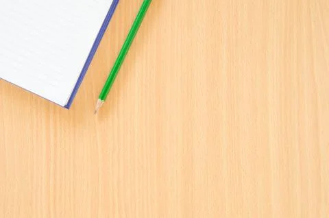 White note book and green pencil on beech color background table with copy sp Stock Photos