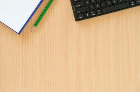 White note book and green pencil and black keyboard put on beech color table  Stock Photos