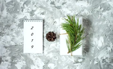 White notebook, pine cone, pine branch on a concrete background. View from .. Foto stock