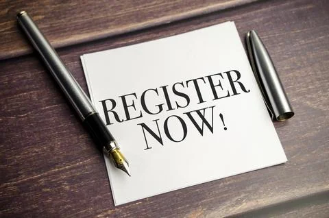 White notepad and ink pen on the wooden desk Register now concept Stock Photos