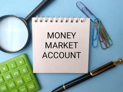 A white notepad displaying the text MONEY MARKET ACCOUNT sits surrounded by.. Fotos de archivo