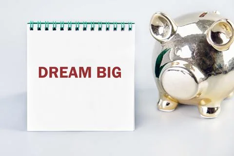 A white notepad with the phrase DREAM BIG stands prominently next to a shiny  Stock Photos