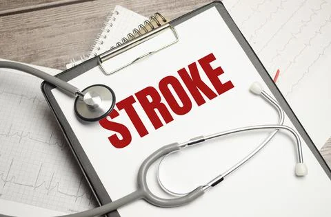White notepad with red text STROKE and stethoscope on a blue background. Stock Photos