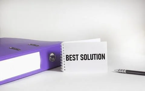 On a white notepad, the text BEST SOLUTION, next to a pen and a folder on a w Stock Photos