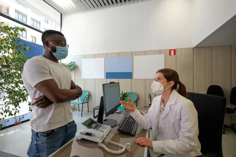 White nurse explaining the procedure to black patient Stock Photos