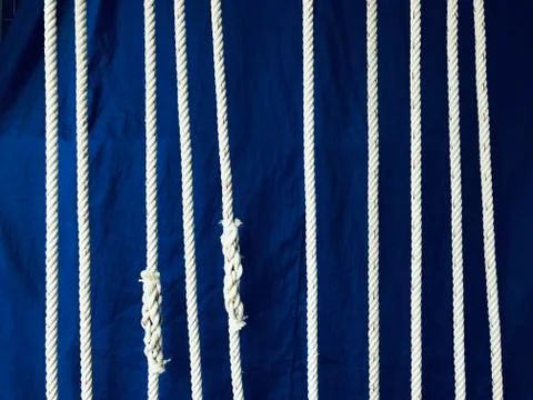 White nylon strings with dark blue cotton fabric on a background Stock Photos