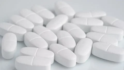 White oblong tablets with a dividing strip rotate macro 库存影片 233821820