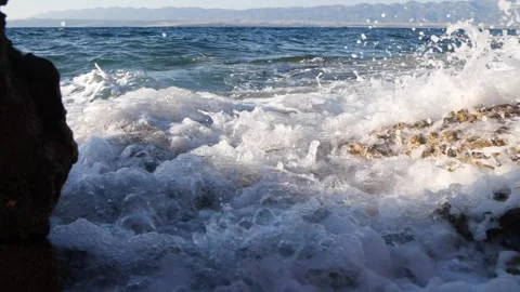 White ocean waves crashing powerfully against rocky shore in summer Stock Footage 337410121