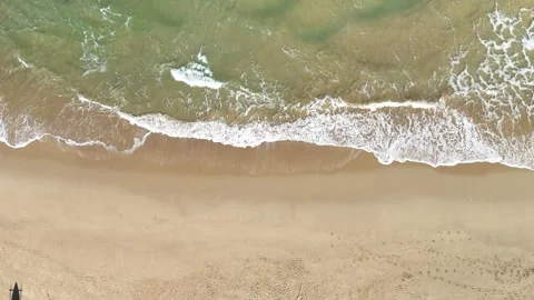 White Ocean Waves Rolling Toward Sandy Beach Under Clear Blue Sky 動画素材 345639619