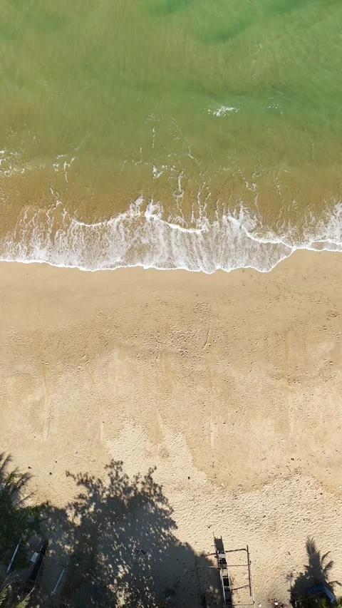 White Ocean Waves Rolling Toward Sandy Beach Under Clear Blue Sky Stock Footage 345652019
