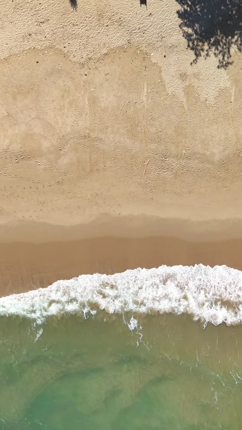 White Ocean Waves Rolling Toward Sandy Beach Under Clear Blue Sky Stock Footage 345655414