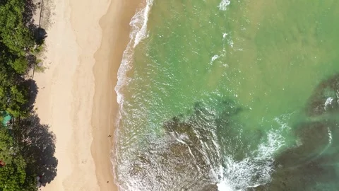 White Ocean Waves Rolling Toward Sandy Beach Under Clear Blue Sky Stock Footage 345657982