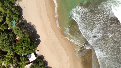 White Ocean Waves Rolling Toward Sandy Beach Under Clear Blue Sky Stock Footage 345705549
