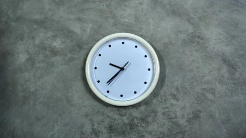 White office clock hangs on a gray concrete wall. Time lapse, timelapse Stock Footage
