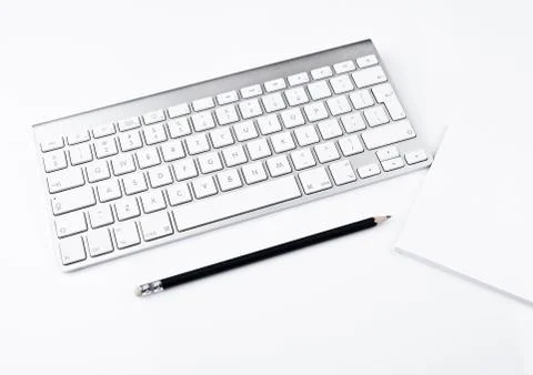 White office computer keyboard with black pencil white background table Stock Photos