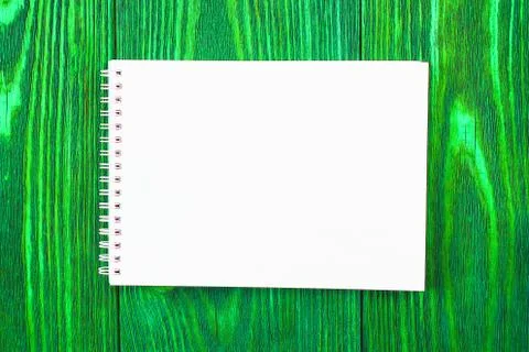 White office Notepad lies on a bright lime green colored wooden background, m Stock-Fotos