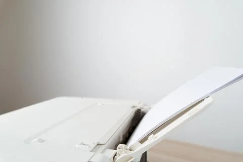 White office printer with a stack of blank A4 paper loaded in the feeder tray Stock Photos