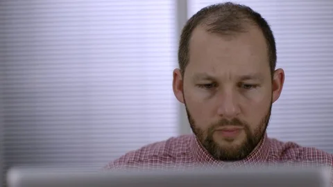 A white office worker sits down and logs on to his laptop computer in the office Stock Footage 73124206