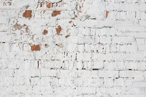 White old brick background. Old brick wall painted with cracked white paint. Stock Photos