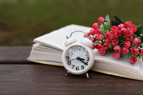 White old clock alarm clock morning on nature on a wooden bench Stock Photos