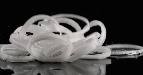 White onion rings falling on a black background slow motion. Close up view, shot Stock Footage 108654827