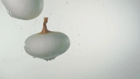 White onions falling into water Stock Footage 84773681