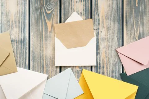 White open envelope with open kraft paper card on gray wooden background Stock Photos