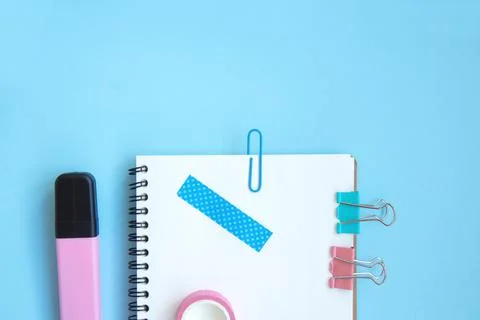 White open notebook and elements of stationery on a light blue background Foto stock