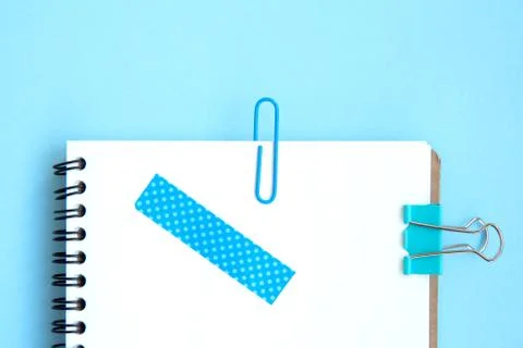 White open notebook with blue elements on a light blue background Stock Photos