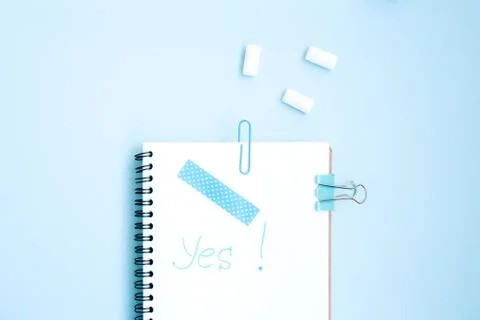 White open notebook with blue elements and gum on a light blue background Stock Photos