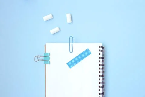 White open notebook with blue elements and gum on a light blue background Stock Photos
