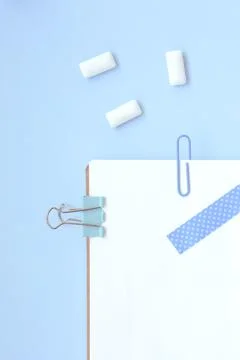 White open notebook with blue elements and gum on a light blue background Foto stock