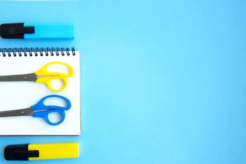 White open notebook with blue markers and scotch on a bright blue background Stock Photos