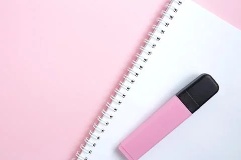 White open notebook with pink marker on pink background Stock Photos