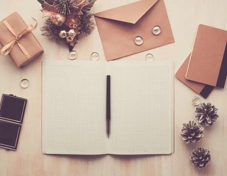 White open notepad, envelope and Christmas decoration lying on beige wooden Foto stock