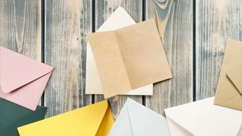 White opening envelope on wooden background. Multicolored envelopes fall from Stock Footage 221702872