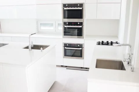 White organised kitchen with modern elements in an apartment Stock Photos