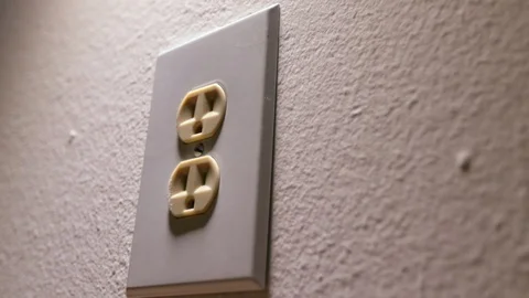 White outlet white wall side shadow lighting plugging chord in Stock Footage 93052815